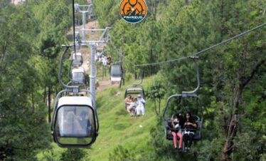 Lovers on a chairlift ride above pine forests in Patriata, Murree