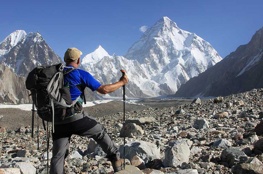 Group trekking across the Baltoro Glacier under towering Karakoram peaks
