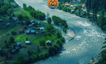 Camping setup in Neelum Valley near riverbanks and pine-covered hills