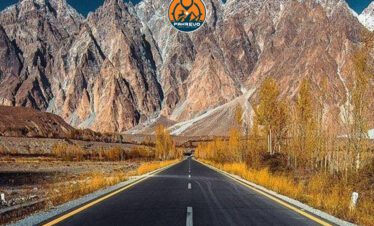 Tents pitched beside a glacial stream with snowy mountains in the background in Hunza or Skardu